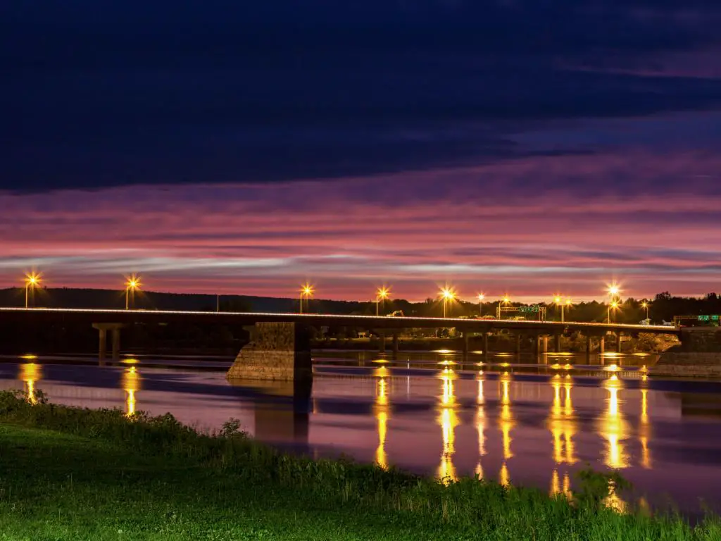 Fredericton, New Brunswick, Canadá con un puente en Fredericton tomado de noche.