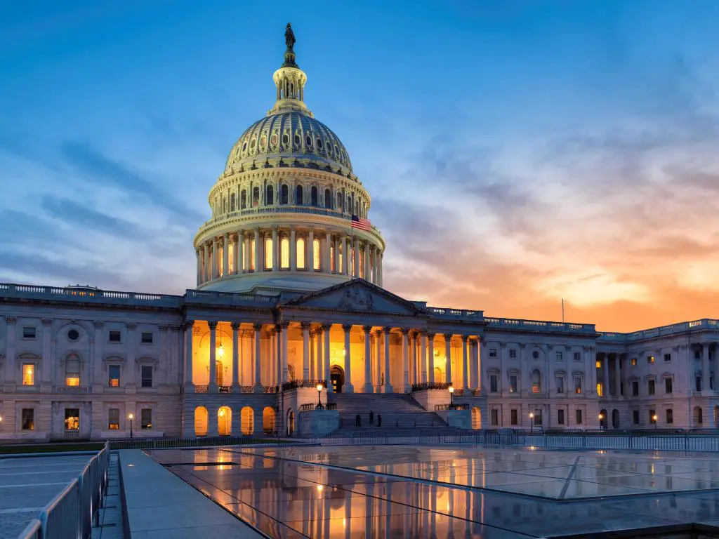Washington DC, EE.UU. tomada en el edificio del Capitolio de los Estados Unidos al atardecer con un cielo impresionante y reflejado en el suelo de cristal en primer plano. 