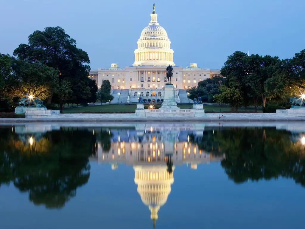 Washington DC, EE. UU. Tomada en el edificio del Capitolio de los Estados Unidos después del anochecer reflejado en el agua en primer plano.