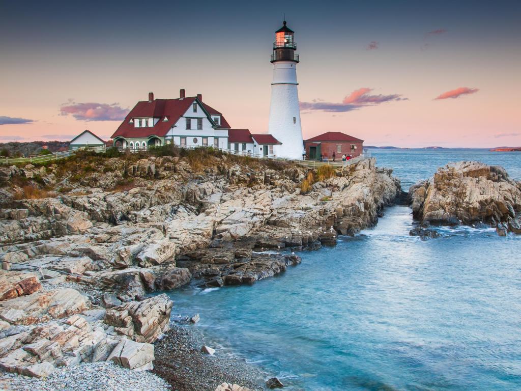 Faro de Cape Elizabeth, Portland, Maine, EE. UU. Tomado a primera hora de la tarde con rocas y el mar en primer plano.