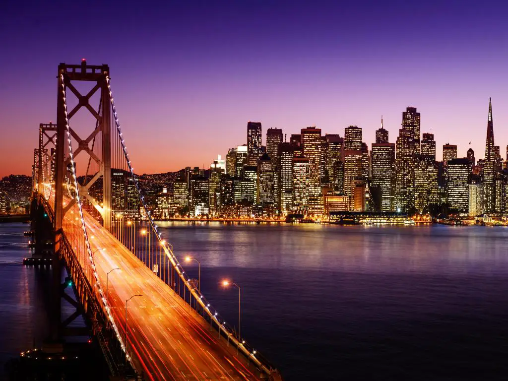 Horizonte de San Francisco y puente de la bahía al atardecer, California