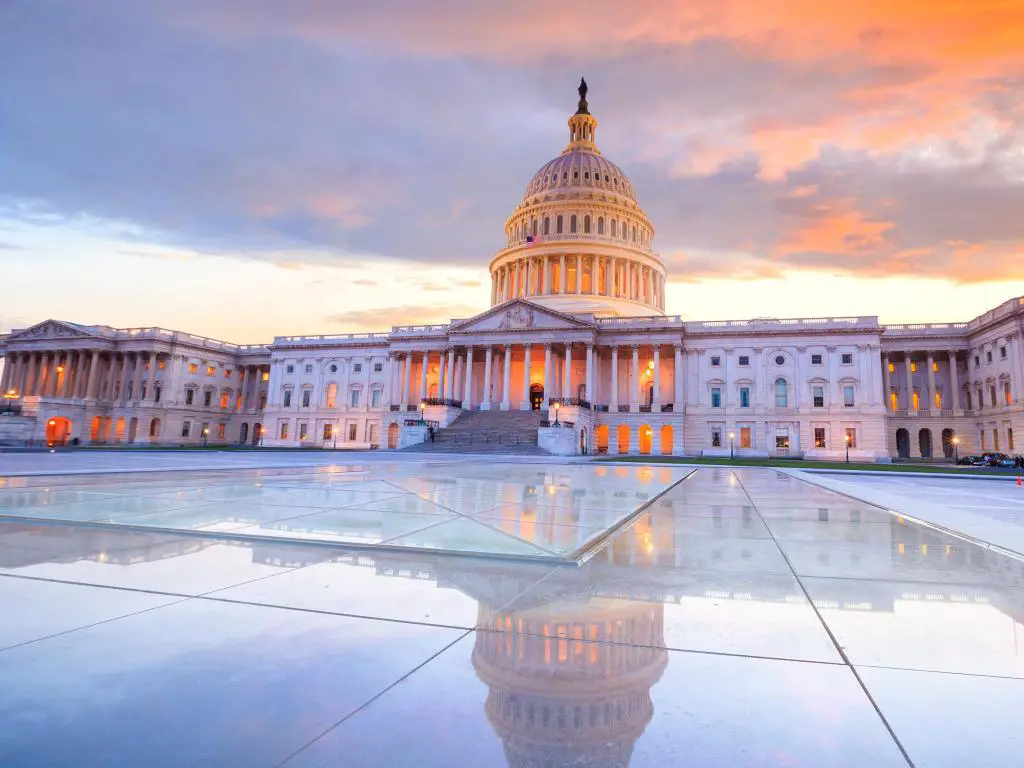 Capitolio de los Estados Unidos, Washington DC, EE.UU. con la cúpula iluminada por la noche y reflejada en el suelo y tomada al atardecer. 