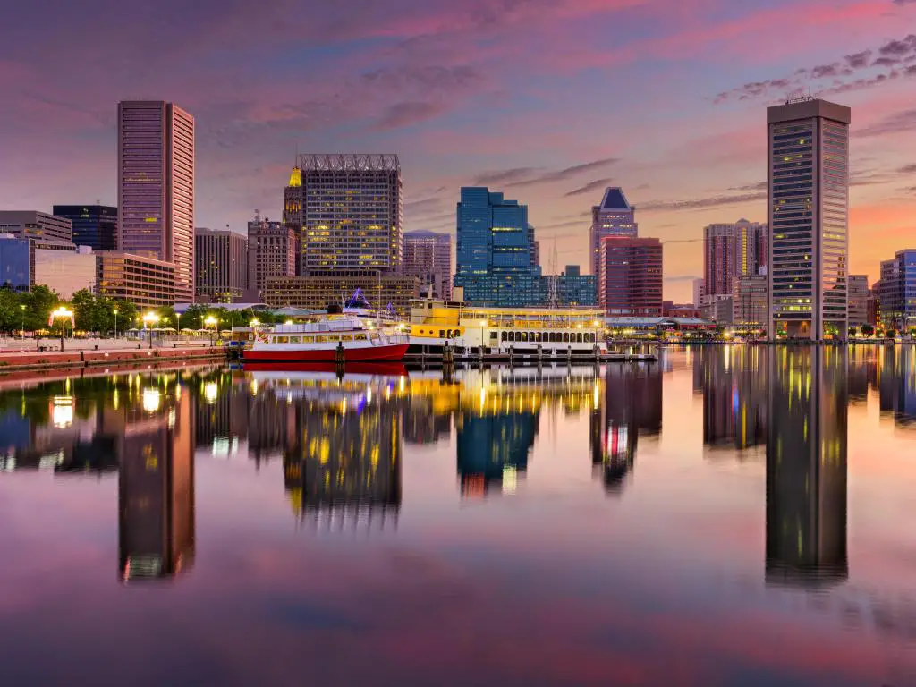 Baltimore, Maryland, EE.UU. con el horizonte de la ciudad en la distancia en el Inner Harbor, tomada a primera hora de la tarde con la ciudad reflejando el agua.