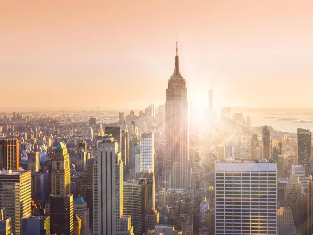 Ciudad de Nueva York, Estados Unidos con el horizonte del centro de Manhattan con el Empire State Building iluminado y rascacielos al atardecer. 