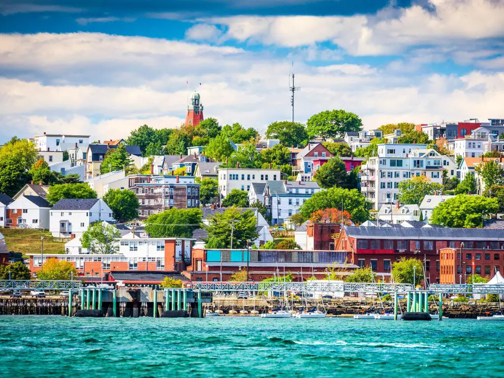 Portland, Maine, EE. UU., mostrando el paisaje urbano costero en el fondo, el mar turquesa en primer plano y tomado en un día soleado.
