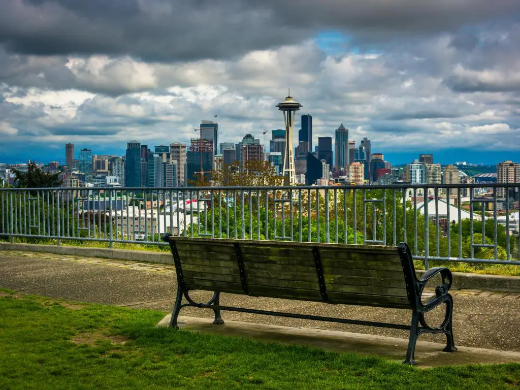 Seattle, Washington, EE.UU. con un banco y una vista del horizonte del centro de Seattle en primer plano en un día nublado.