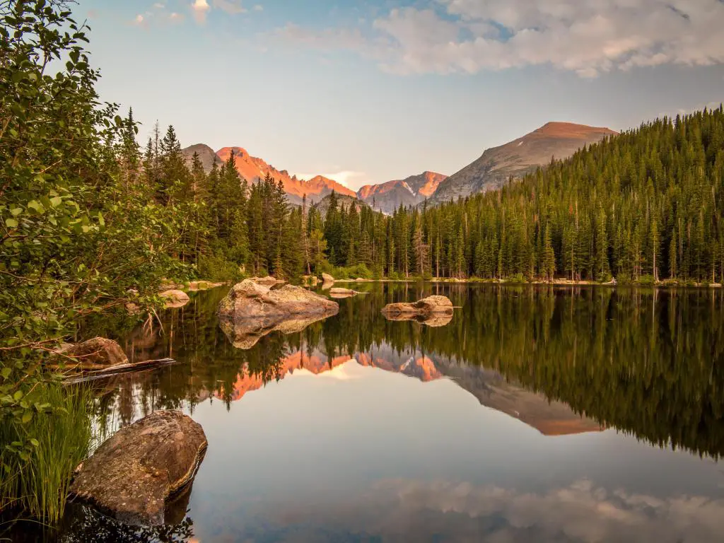 Reflexión al atardecer de montañas y rocas en Bear Lake en el Parque Nacional Rocky Mountain, Colorado.
