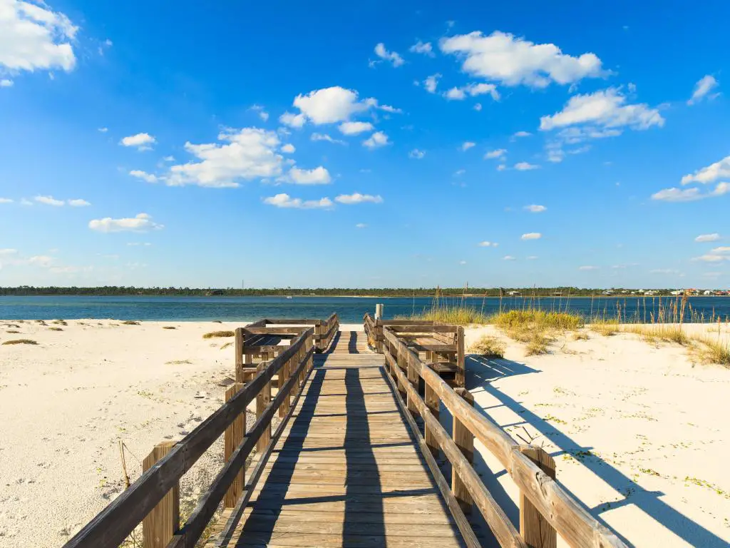 Hermosa playa Perdido en Pensacola, Florida.  La foto muestra un muelle sobre arena en un día soleado.