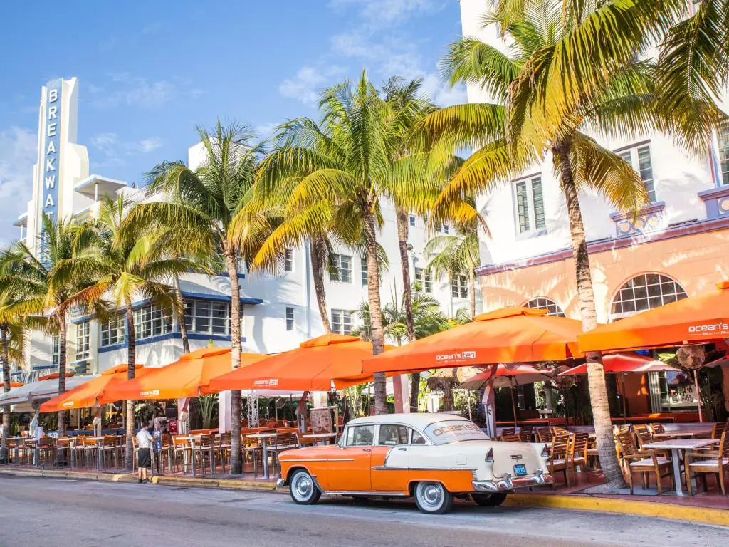 Ocean Drive en Miami Florida, con un auto antiguo estacionado en la calle bordeada de palmeras
