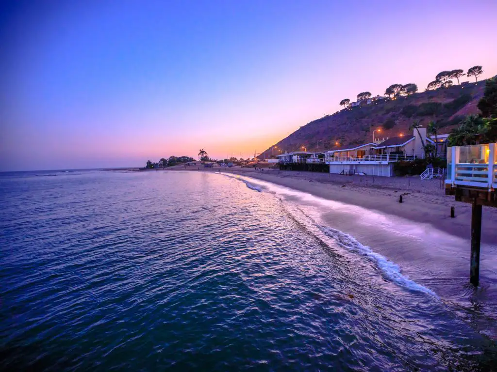 Malibu, California, Estados Unidos, con un pintoresco paisaje costero con las montañas de Santa Mónica y la playa Surfrider al atardecer. 