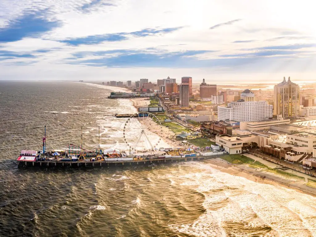 Atlantic City, EE.UU. tomada a última hora de la tarde como un panorama aéreo a lo largo del paseo marítimo con rascacielos a lo largo de la playa y una noria en el amplio paseo. 