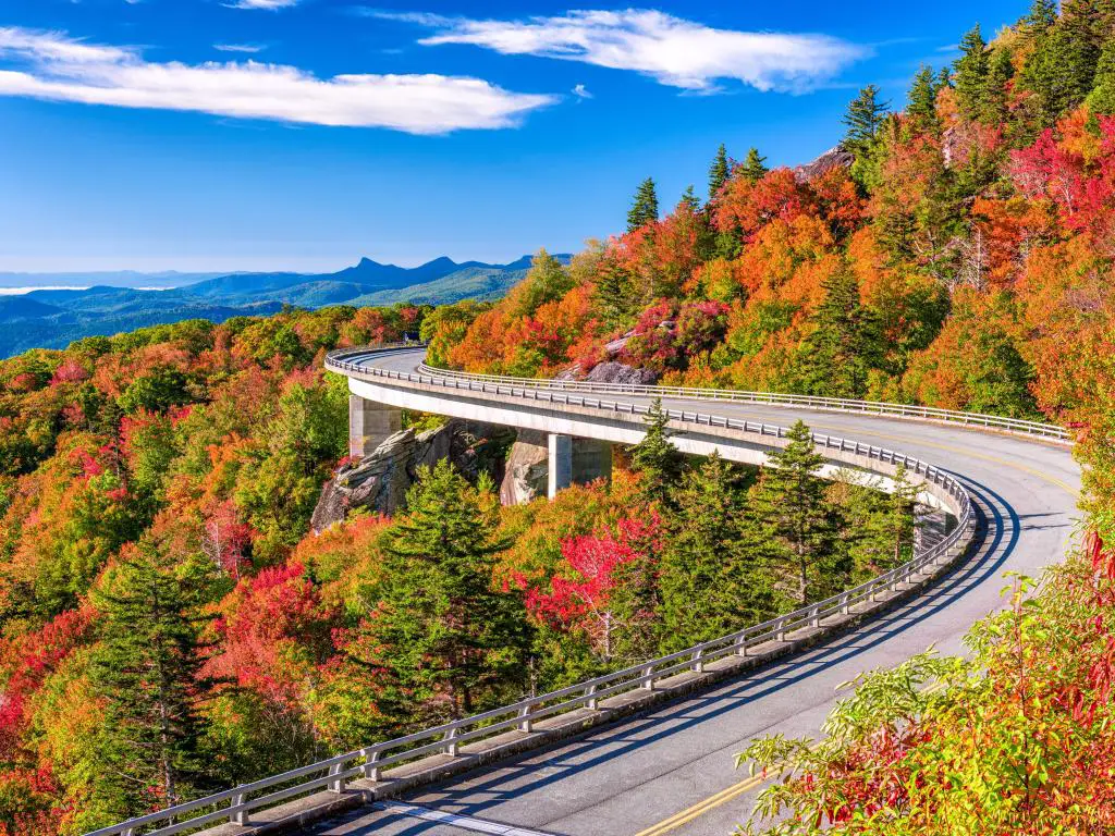 El viaducto abraza la ladera de la colina con muchos árboles en colores otoñales