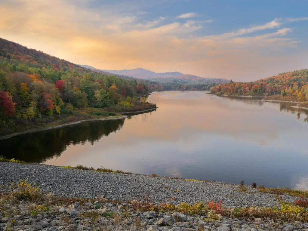 Montpelier, Green Mountains, Vermont tomada en el embalse de Wrightsville al atardecer con el lago en primer plano y árboles caídos en la distancia. 