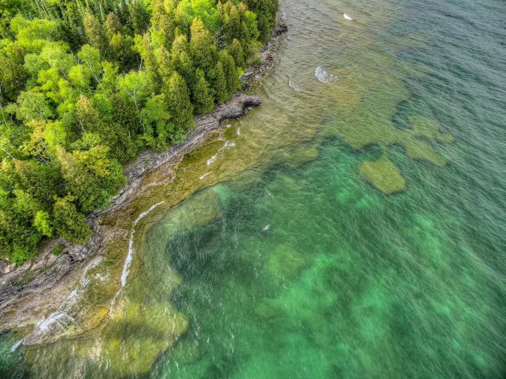 Whitefish Lake State Park, Wisconsin, EE.UU. tomado como una toma aérea mirando hacia el agua clara y el denso bosque del parque.