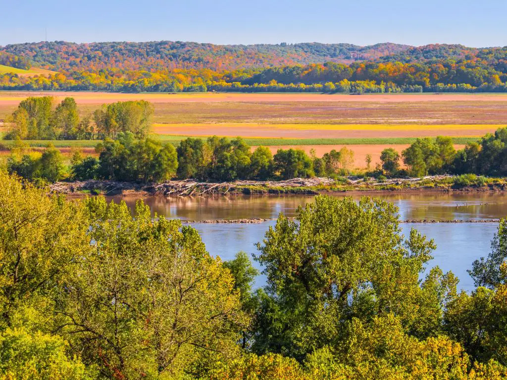 Orillas del río Missouri, Estados Unidos con una hermosa vista del río en otoño;  campos en el banco inferior y acantilados leñosos en segundo plano en un día soleado.