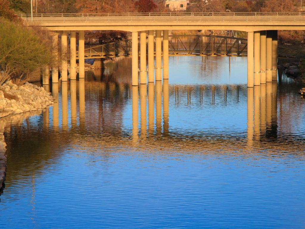 Puente de color arena sobre un río tranquilo a la luz de la tarde