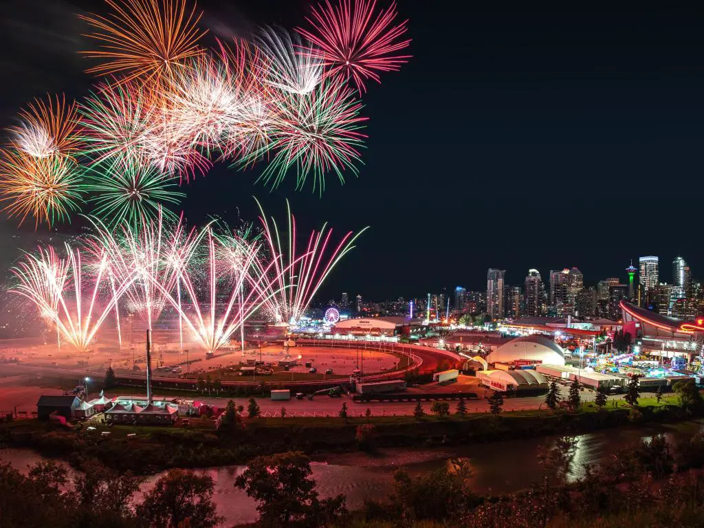 Calgary Stampede, Calgary, Canadá, con un colorido espectáculo de fuegos artificiales sobre el cielo nocturno con el horizonte del centro de Calgary como telón de fondo durante la Calgary Stampede anual.