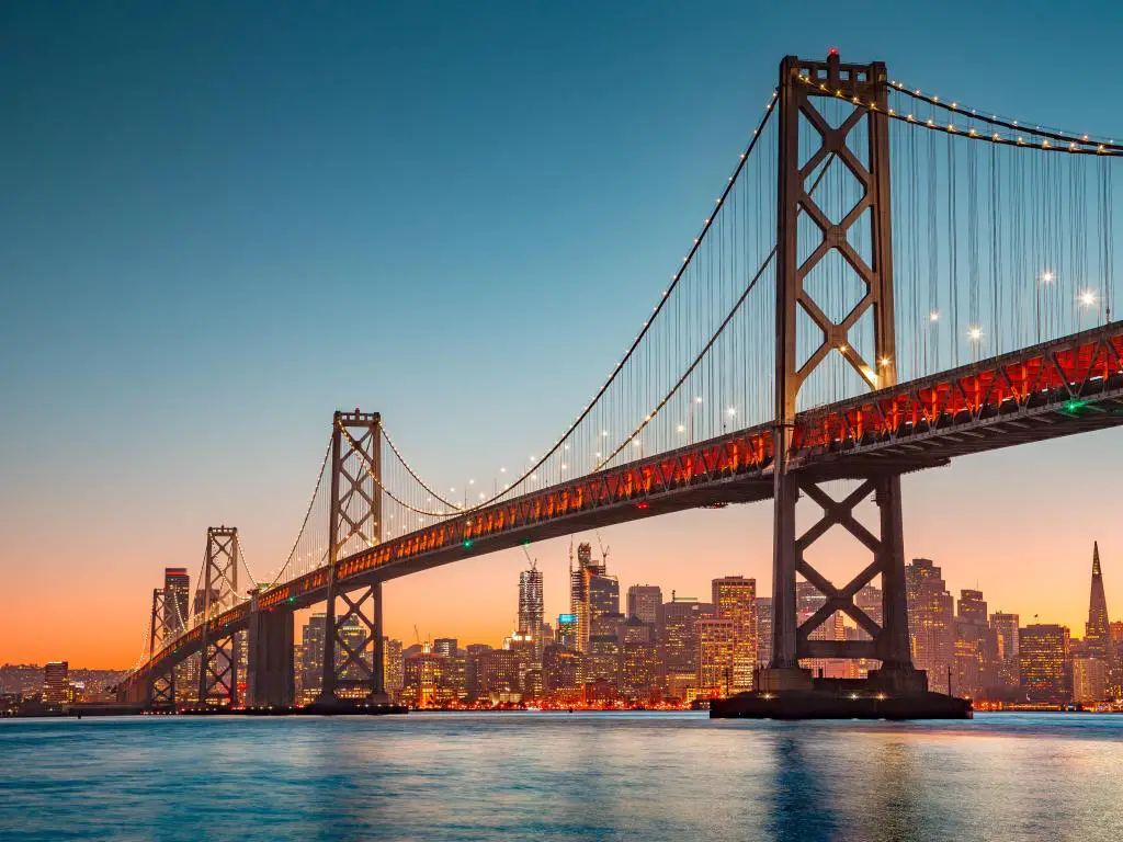 Área de la Bahía de San Francisco, California, EE.UU. tomada del famoso Puente de la Bahía de Oakland iluminado con una hermosa luz dorada al atardecer con el horizonte de la ciudad a lo lejos.