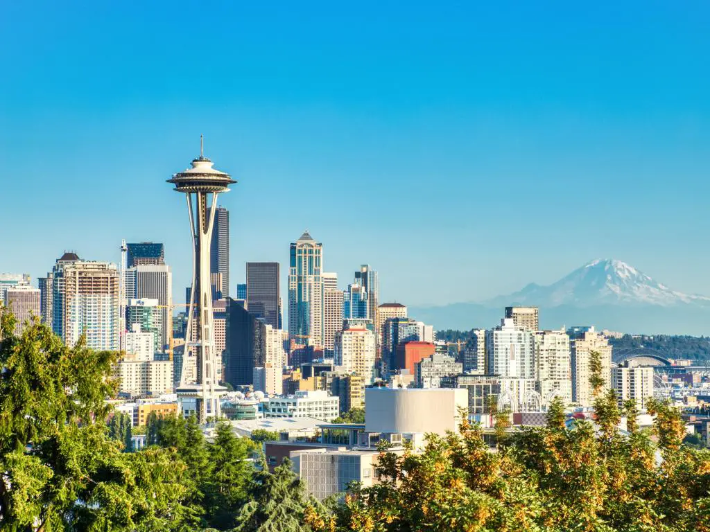 Seattle, Washington, EE.UU. con el paisaje urbano y el Monte Rainier al fondo en un día soleado con un cielo azul claro.