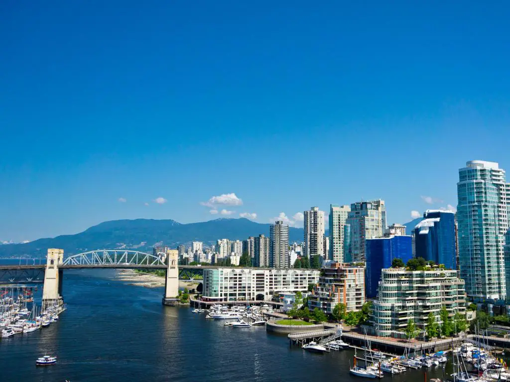 Vancouver, Columbia Británica, Canadá, con una hermosa vista de la ciudad al fondo y el puente que cruza el agua, además de montañas a lo lejos en un día claro y soleado.