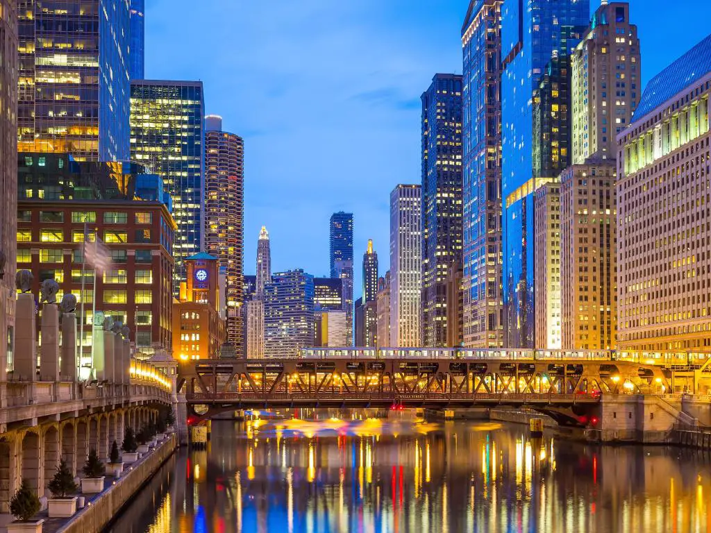 Chicago, Illinois tomada en el centro de la ciudad con el río Chicago y edificios altos a ambos lados por la noche y un puente en el centro. 