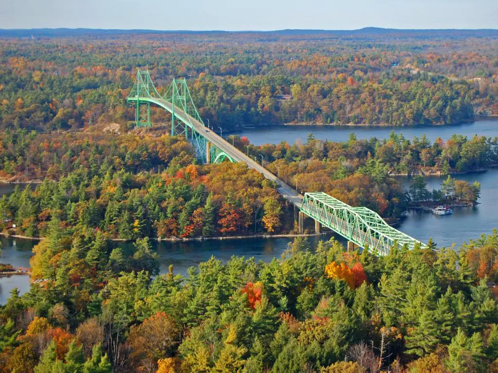 Puente verde cruzando islas fluviales cubiertas de árboles en colores de otoño