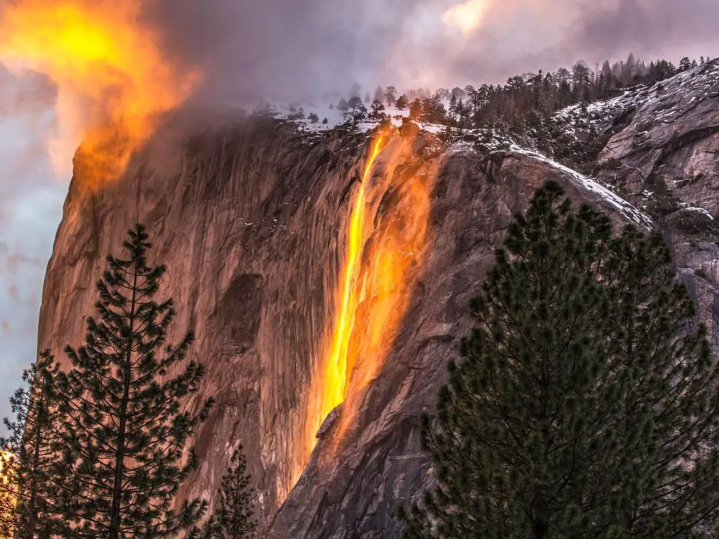 Una luz naranja intensa cae como una cascada por un acantilado escarpado en un raro fenómeno natural