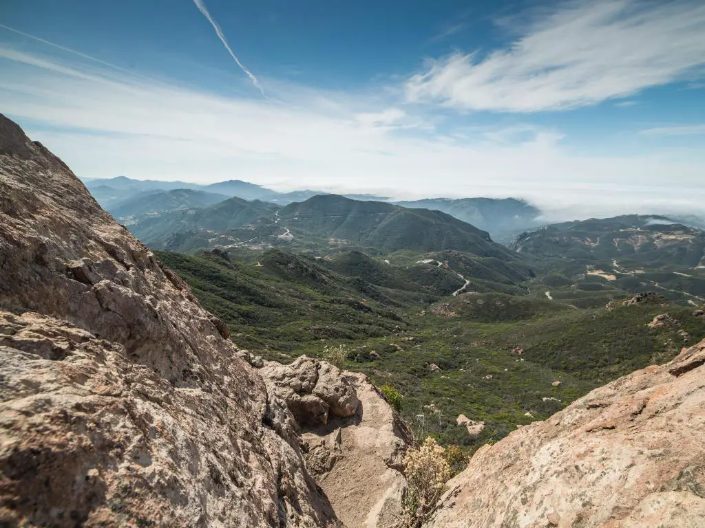 Recreación Nacional de las Montañas de Santa Mónica, California, con vistas desde la cumbre del Pico Sand Stone y verdes colinas en la distancia con un horizonte brumoso. 