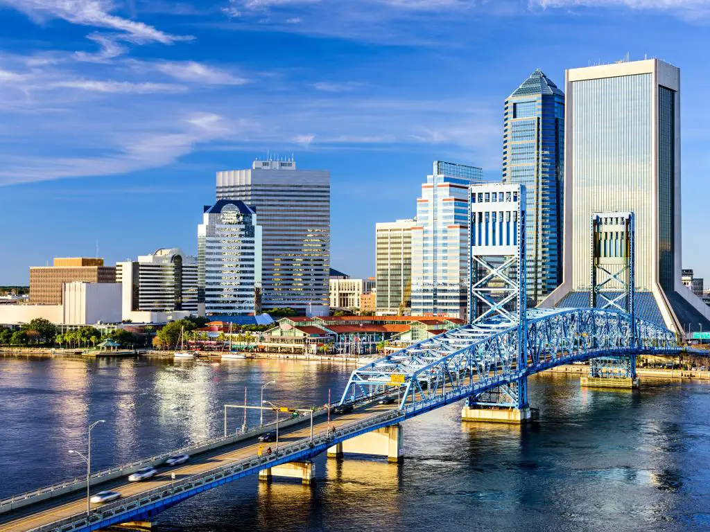 Jacksonville, Florida, que muestra el horizonte del centro de la ciudad en el fondo y el río St. Johns en primer plano con un puente que cruza los dos.