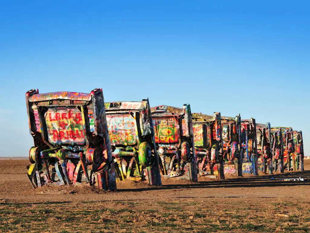 Autos cubiertos de grafitis se mantienen erguidos en el desierto