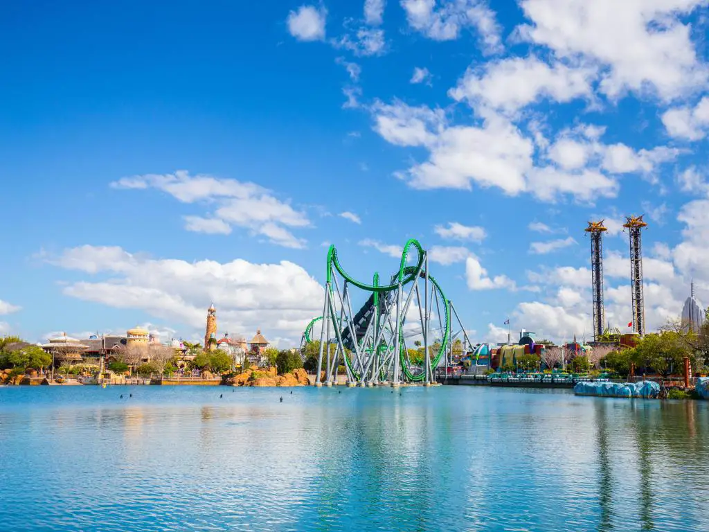 Walt Disney Orlando, EE. UU. con un gran lago en primer plano y paseos en el fondo en un día soleado con un cielo azul arriba.