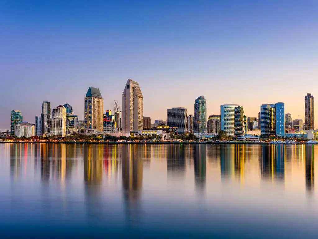 El horizonte del centro de San Diego, California, al atardecer, con sus altos edificios reflejados en el agua.