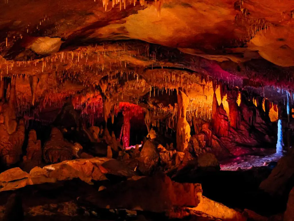 Cavernas del espacio interior, Georgetown, una cueva oscura iluminada con rojos, naranjas y amarillos.