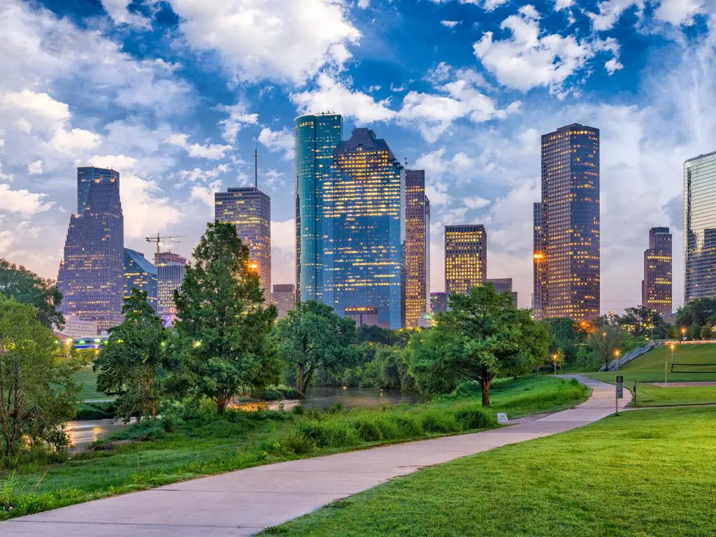 Houston, Texas, a primera hora de la tarde con el horizonte de la ciudad al fondo y un parque verde en primer plano. 