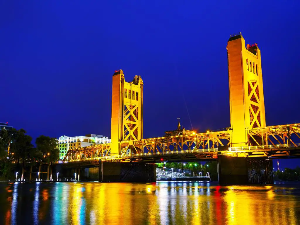 El puente levadizo Golden Gates se iluminó en Sacramento por la noche con el reflejo en el agua.