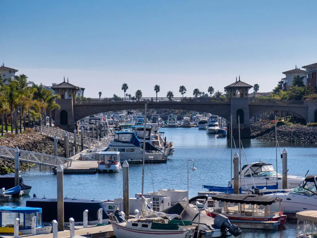 Marina en Oxnard, California, con yates, palmeras y un puente que cruza el canal
