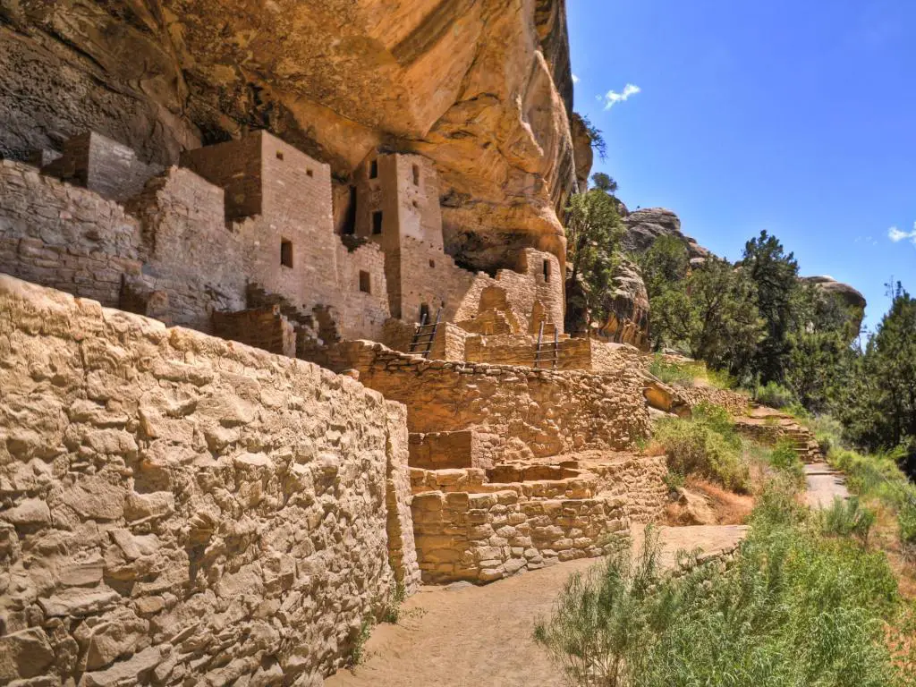 Edificios históricos tallados en Cliff Palace en el Parque Nacional Mesa Verde, con cielo azul arriba