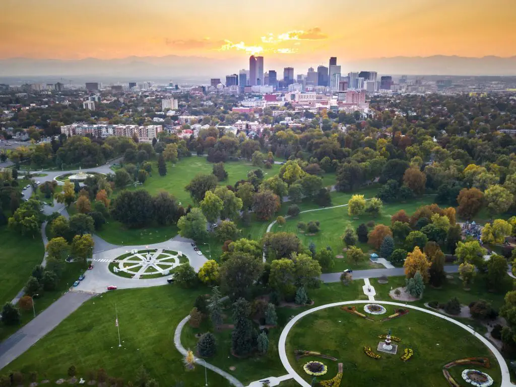 Paisaje urbano de Denver, vista aérea desde el parque de la ciudad en primer plano con la ciudad al fondo al atardecer.
