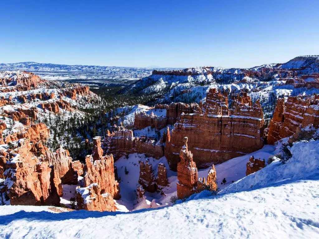 Parque Nacional Zion en invierno con nieve cubriendo las montañas, árboles y roca roja en Utah