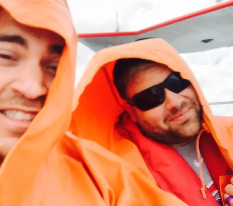 Dos hombres con impermeables naranjas en un barco