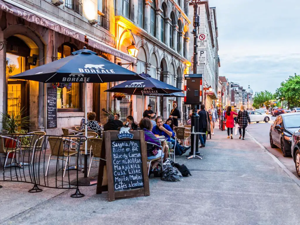 Zona del casco antiguo de Montreal con gente sentada junto a la calle en un restaurante exterior