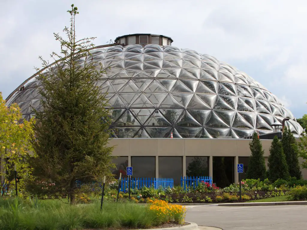 El impresionante Centro Ambiental del Jardín Botánico de Des Moines en Iowa con una cúpula de vidrio y una serie de hermosas flores a su alrededor durante el verano