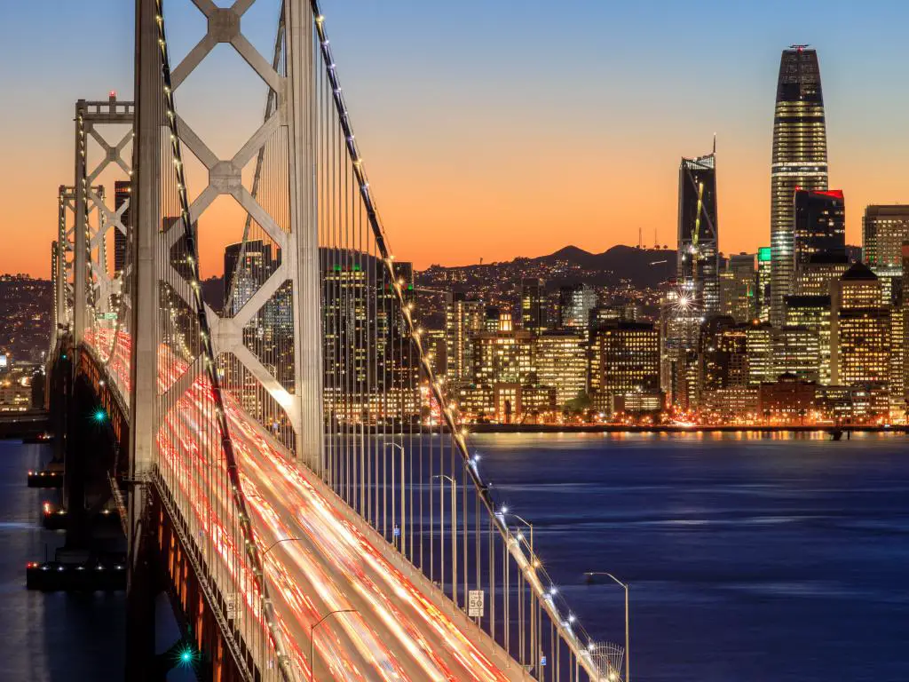 Una vista impresionante del Puente de la Bahía de Oakland y una vista de las luces de la ciudad, el horizonte de San Francisco al atardecer.