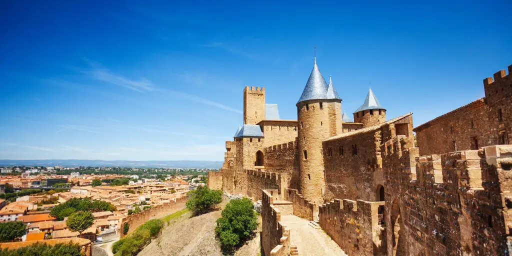Las murallas de la Cité de Carcassonne en Francia, con torres redondas, mirando hacia abajo sobre la ciudad.