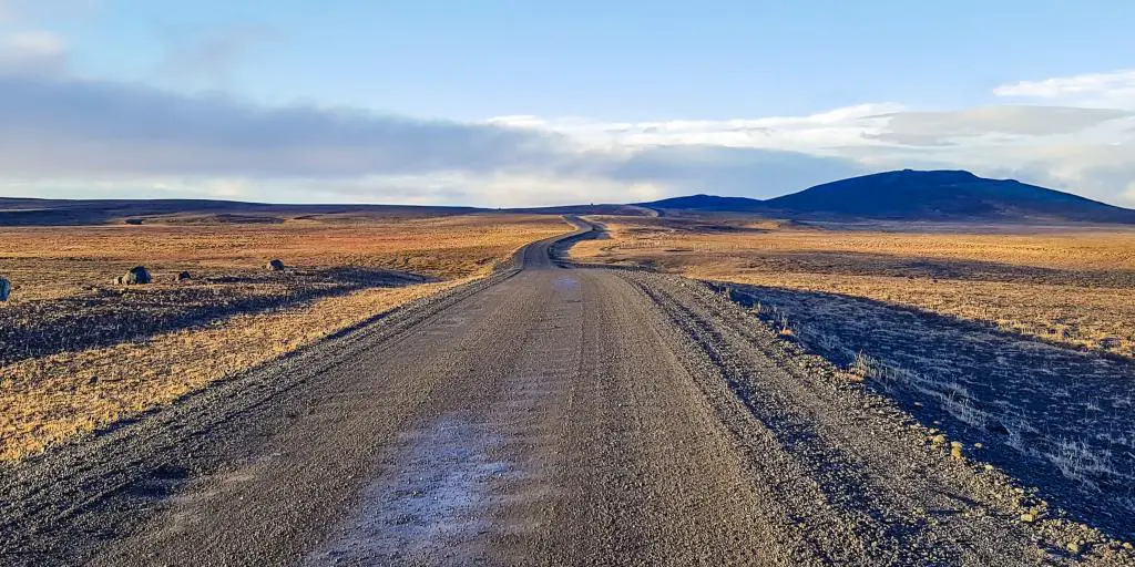 Carretera F35 que serpentea a través de la tierra con montañas en la distancia en Islandia 