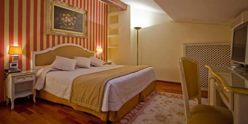 Un dormitorio con paredes a rayas rojas y amarillas y un tragaluz en el Hotel Porta San Mamolo en Bolonia