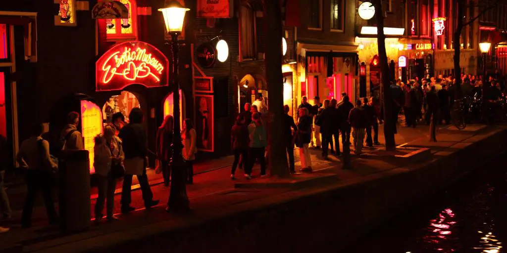 Gente paseando por el Barrio Rojo de Ámsterdam por la noche 