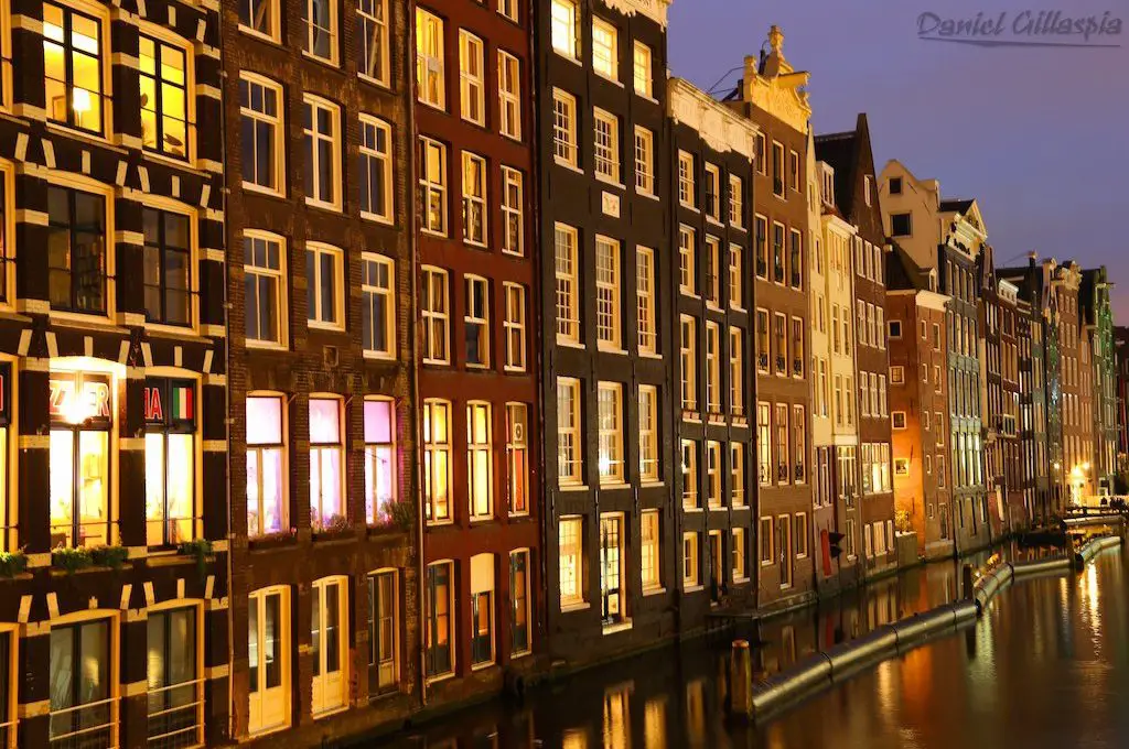 Canal de la línea de edificios en Amsterdam en la noche