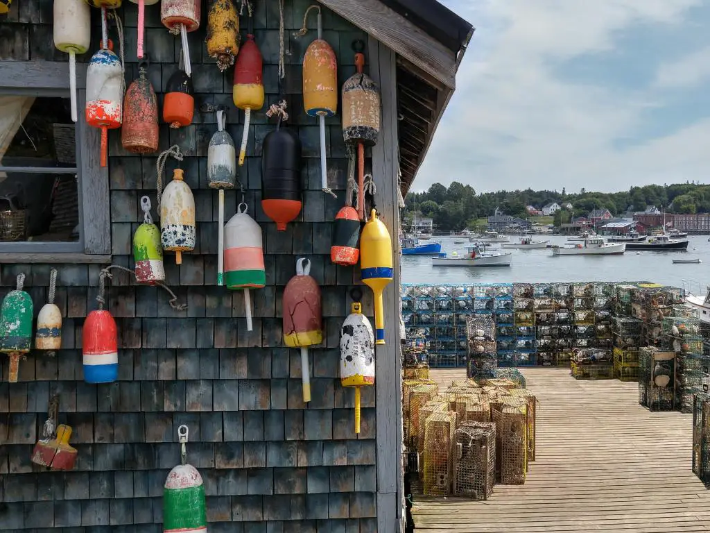 Muelle de pesca de langosta de Nueva Inglaterra Las boyas marcadoras para trampas de langosta decoran el costado de una choza de pesca en un muelle en Maine.