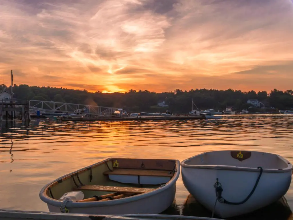 Amanecer de verano temprano en la mañana sobre aguas tranquilas y barcos john cerca de un muelle de langostas en funcionamiento en Muscongus Bay, Maine